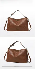 Detail of brown woven leather texture with gold zipper and adjustable strap on handbag