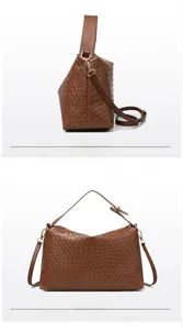 Detail of dark brown woven tote with gold hardware and removable shoulder strap