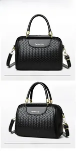 Detail of black woven leather boston bag with gold hardware and brand logo