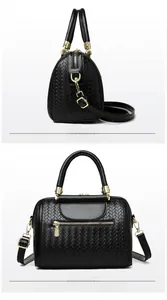 Detail view of black woven texture on Boston bag with gold-tone hardware and zippers