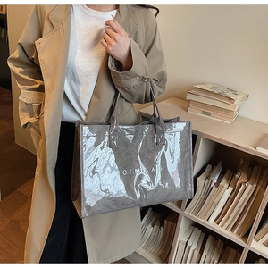 Detail of grey tote bag with glossy PVC coating and textured fabric shown on model