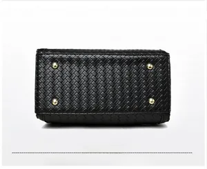 Close-up of woven leather bag bottom with four protective golden metal feet