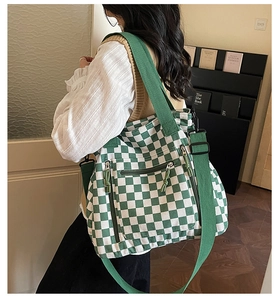 Green checkerboard tote bag with dual straps and multiple pockets on a lifestyle model
