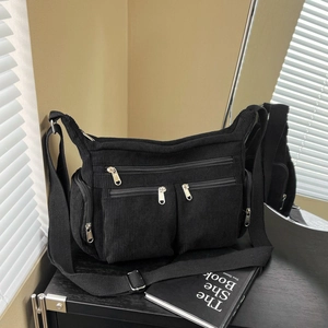 Grand sac fourre-tout noir en velours côtelé avec plusieurs poches zippées et bandoulière