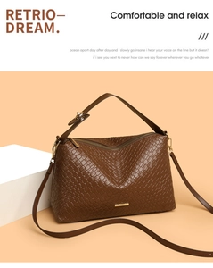 Detail of dark brown woven texture handbag with golden hardware and adjustable strap