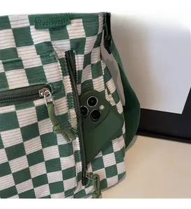 Macro detail of side zipper pocket on green checkered corduroy tote bag for storage
