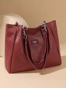 Detail of woven burgundy tote bag featuring silver chain strap and refined PU texture