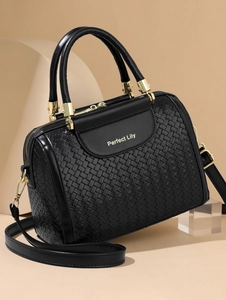 Detail of black woven texture and golden Perfect Lily logo on luxury boston handbag