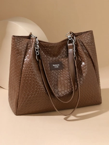 Close-up of woven texture and silver chain strap on large brown faux leather tote bag