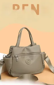 Detail of khaki nylon handbag showing spacious compartments and adjustable shoulder strap