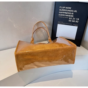 Detail view of the transparent PVC tote bag with a brown faux leather inner compartment