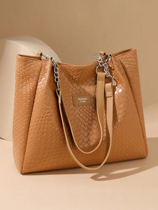 Close-up of woven texture on light brown large tote bag with silver chain straps