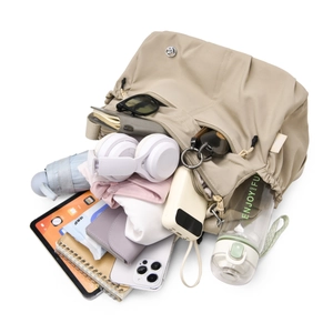 Spacious water-resistant nylon shoulder bag showing interior storage for iPad and essentials