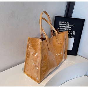 Detail of minimalist waterproof PVC tote bag with brown inner paper bag and TOTE BAG text