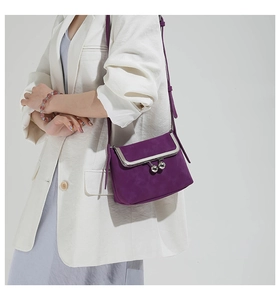 Detail of a deep purple mini crossbody bag with retro metal frame and silver ball clasp