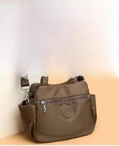 Detail view of large nylon handbag with multi-pocket design and adjustable strap