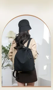 Waterproof black nylon backpack with top handle and metal zippers shown on model