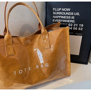 Detail of waterproof transparent PVC tote bag with brown fabric lining and white text