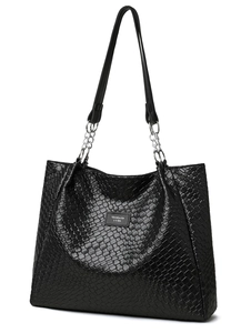 Close-up of black woven tote bag with silver chain strap and minimalist brand label