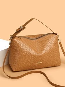 Detail of tan woven texture tote bag with golden zipper and adjustable shoulder strap