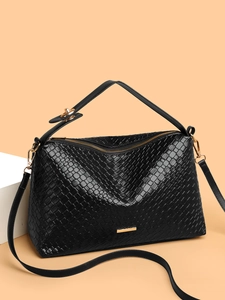 Close-up of black woven shoulder bag showing fine texture and golden metal hardware details
