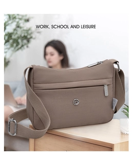 Close-up of lightweight nylon crossbody bag featuring layered zippers and logo