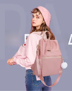 Dettaglio dello zaino in tessuto Oxford rosa con gancio laterale e pompon in peluche