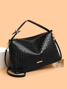 Close-up of woven texture on black crossbody bag with golden zipper and luxury finish