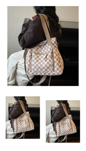 Detail of checkered tote bag featuring three front zippers and wide fabric shoulder strap