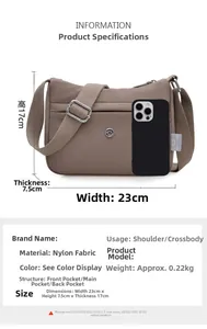 Detailed view of the nylon crossbody bag showing 23x17cm size compared to a mobile phone