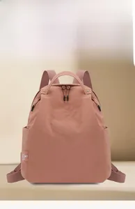Close-up of pink water-resistant nylon backpack with double zippers and side pockets