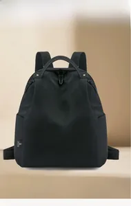 Detail of waterproof black nylon backpack showing reinforced handle and side pocket