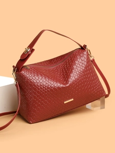 Detail of red woven leather handbag showing fine cross-weave texture and gold hardware