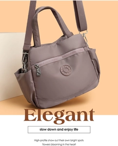 Detail of mauve nylon shoulder bag showing the rubber logo and horizontal zipper pocket