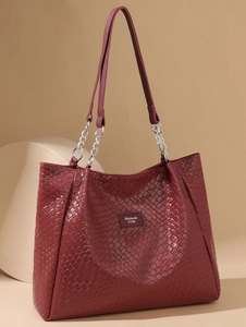Macro detail of wine red woven PU leather tote bag with metallic chain strap and logo