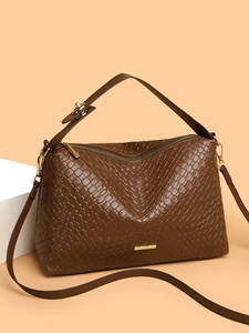Detail of dark brown woven texture handbag with golden hardware and logo plate