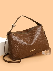 Macro detail of dark brown woven leather texture on a high-capacity commuter tote bag