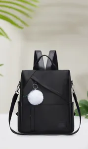 Detailed view of black waterproof oxford backpack with front zipper and plush ball detail