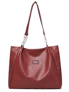 Detail of burgundy woven tote bag showing leather texture and silver chain strap attachment