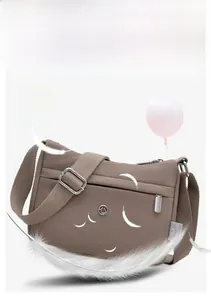 Lightweight taupe nylon crossbody bag floating with feathers to show its soft material