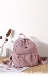 Detail of light pink mini Oxford canvas backpack with pleated design and side pockets