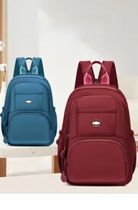 Detail view of water-resistant nylon backpacks in navy blue and burgundy with multi-pockets