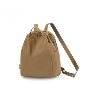 Detail of a brown nylon backpack featuring water-resistant texture and side pockets