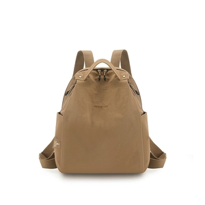 Detailed close-up of water-resistant khaki nylon fabric and RU&NU embroidery on the backpack