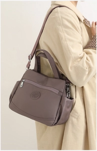 Detail of multi-layer waterproof nylon crossbody bag with durable zippers and handles