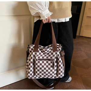 Detail of coffee checkered tote bag with corduroy texture and side zipper pockets