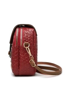Detail of red woven crossbody bag with dual golden zippers and adjustable leather strap