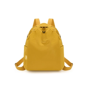 Detailed front view of ginger yellow water-resistant nylon backpack with brand logo