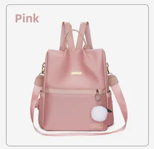 Dettaglio dello zaino rosa in tessuto Oxford con logo in metallo e morbido ciondolo bianco