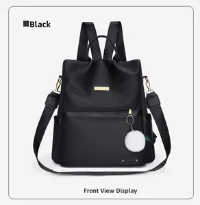 Vista frontale dello zaino nero in tessuto Oxford con logo dorato e pompon bianco
